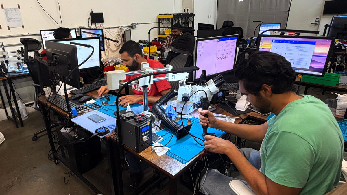 Technicians repairing phones at benches on the 2ndlifephones repair floor